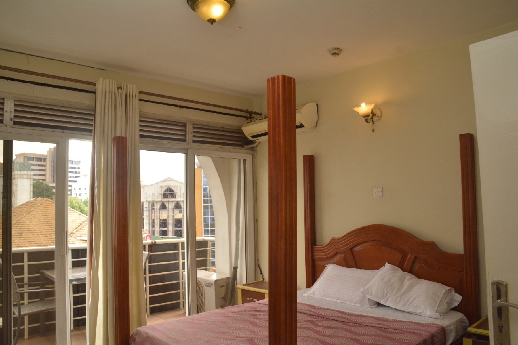 A bedroom in a Shumuk House apartment, with sliding doors onto the balcony