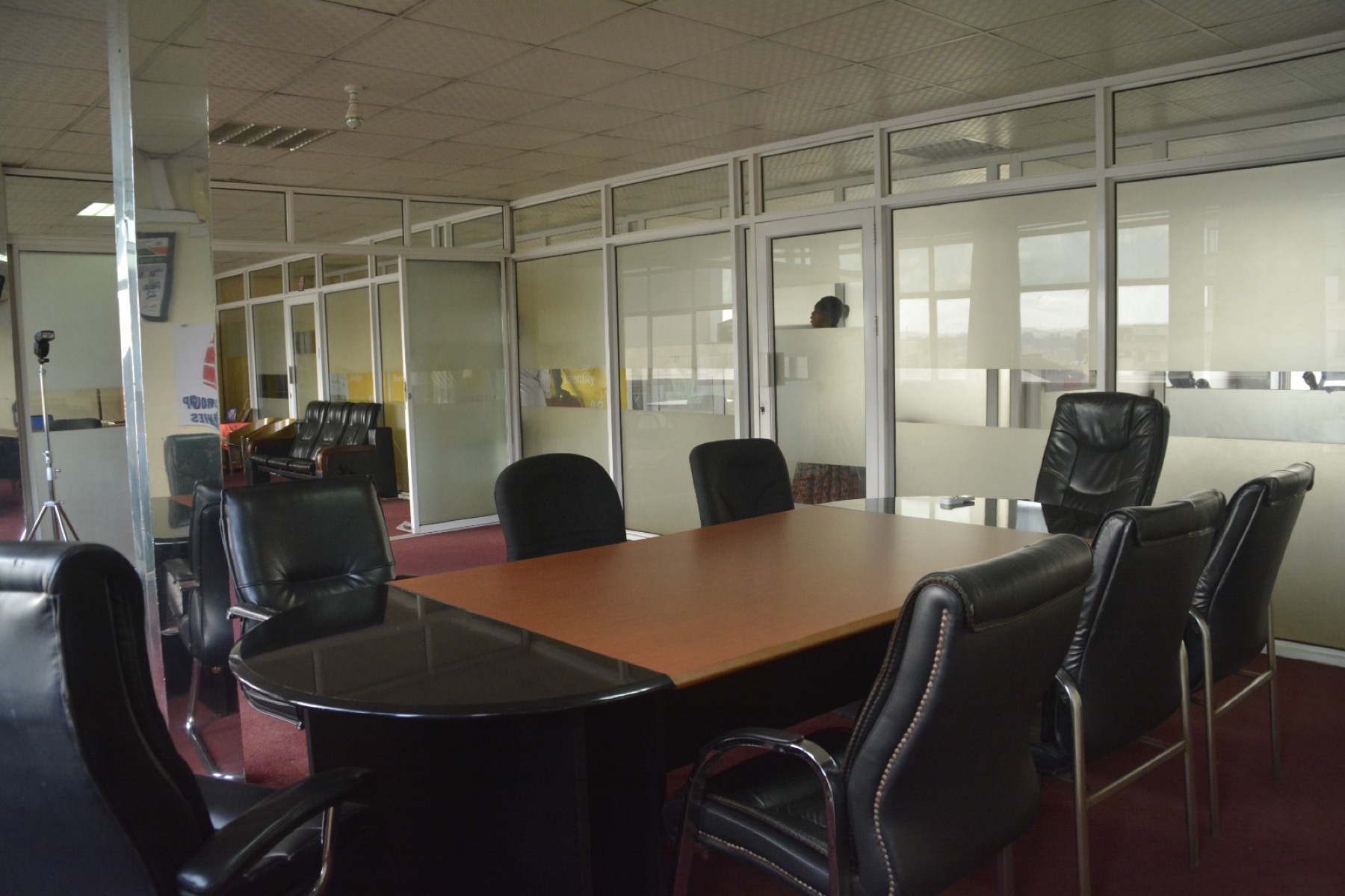 A meeting room on an office floor at Shumuk House, glass partitions and daylight along the far wall
